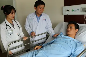 ​  Bác sĩ Cao Minh Thông thăm khám bệnh nhân sau phẫu thuật.