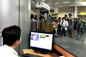 Nhân viên cảng hàng không đang đo thân nhiệt người nhập cảnh 