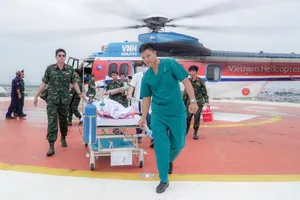 Ekip cấp cứu vận chuyển người bệnh từ sân đỗ trực thăng vào khoa để điều trị