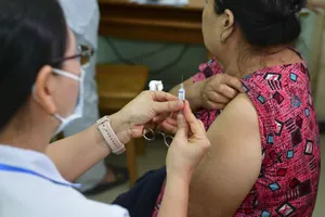 Bác sĩ tiêm vaccine cúm cho người cao tuổi tại Trạm y tế phường An Phú Đông