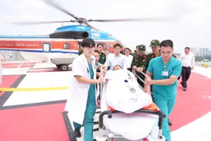 Đội ngũ y bác sĩ, nhân viên Bệnh viện Quân y 175 vận chuyển người bệnh từ trực thăng vào khoa cấp cứu
