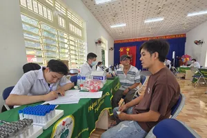Nhân viên y tế khám sức khỏe cho người dân phường Chánh Phú Hòa (Ảnh: THÀNH AN)