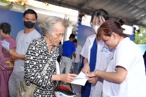 Nhân viên y tế hỗ trợ người cao tuổi khám sức khỏe 