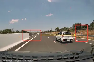 Hình ảnh người dân băng qua đường từ camera hành trình xe ô tô lưu thông trên cao tốc ghi lại