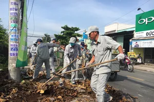 Người dân quét dọn sau khi tham dự hưởng ứng Tuần lễ Quốc gia nước sạch và vệ sinh môi trường