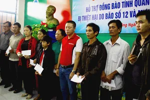 Trao quà hỗ trợ cho các gia đình có người bị thương, chết do mưa lũ. Ảnh: NGUYỄN TRANG