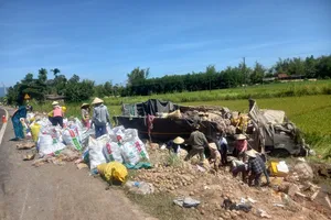 Lật xe tải, đoàn thanh niên và người dân giúp tài xế thu gom trái cây bị đổ 