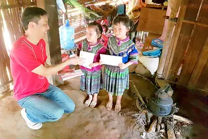 Ông Hiroshi Yokota ,Tổng giám đốc Công ty Canon Việt Nam, tặng quà học sinh nghèo xã Nà Hầu