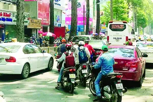  Cổng Bệnh viện Từ Dũ bị lấn chiếm nên các ô tô phải đón khách dưới lòng đường,  gây khó khăn cho người tham gia giao thông