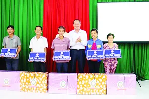  Ông Lưu Hoàng Tân - Chủ tịch, Giám đốc Công ty TNHH MTV Xổ số kiến thiết Đồng Tháp trao bảng tượng trưng  và quà cho 5 hộ nghèo