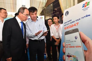 Bí thư Thành ủy TPHCM Nguyễn Thiện Nhân xem ứng dụng Sở Xây dựng trực tuyến SXD247, ra mắt tháng 12-2019 nhằm phục vụ tốt hơn nhu cầu của người dân về lĩnh vực xây dựng. Ảnh: VIỆT DŨNG