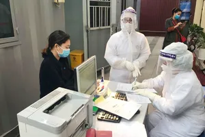  Nhân viên y tế làm thủ tục thăm khám cho người bệnh tại khu vực phòng khám "dã chiến" của Bệnh viện Phụ sản Trung ương. Ảnh: ncov.moh.gov.vn