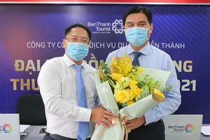 Ông Vũ Đình Quân, nguyên Chủ tịch HĐQT BenThanh Tourist (bên trái) tặng hoa chúc mừng ông Hoàng Tâm Hòa, tân Chủ tịch HĐQT BenThanh Tourist