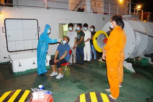 Lực lượng chức năng kiểm tra y tế trước khi tiếp nhận 8 người Myanmar gặp nạn trên biển. Ảnh: VĂN DANH