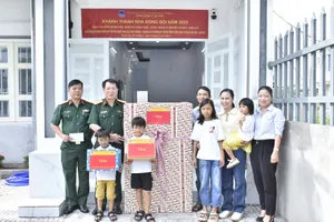 Đại tá Phan Văn Bình, Bí thư Đảng ủy, Chủ tịch Tổng Công ty Ba Son (thứ hai từ trái qua) bàn giao “Nhà đồng đội” và tặng đồ dùng gia đình cho anh Nguyễn Xuân Tiệp. Ảnh: MỸ LƯƠNG