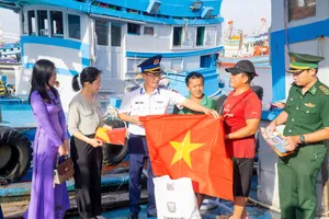 Đại tá Cao Xuân Quận, Phó Chính ủy Vùng Cảnh sát biển 3 cùng đại diện các lực lượng vũ trang đóng chân trên địa bàn, cấp ủy, chính quyền địa phương trao tặng cờ Tổ quốc quốc và các nhu yếu phẩm động viên ngư dân Bà Rịa - Vũng Tàu. Ảnh: MẠNH THẮNG