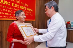 Đồng chí Nguyễn Phước Lộc, Phó Bí thư Thành ủy, Chủ tịch UBMTTQ Việt Nam TPHCM trao Huy hiệu 60 năm tuổi Đảng và tặng hoa chúc mừng đảng viên Dương Thị Xoan (xã Hồ Tràm)