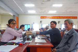 Nhân viên Phòng Giao dịch NHCSXH Bà Rịa - Vũng Tàu giải ngân vốn tín dụng tại xã Long Điền