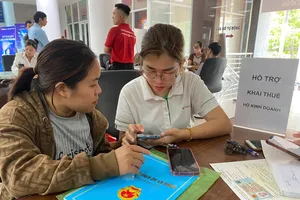 Nhân viên ngân hàng hỗ trợ hộ kinh doanh tại Cơ sở 3 Thuế TP Đồng Nai (phường Trấn Biên). Ảnh: PHÚ NGÂN