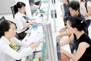 Xây dựng đội ngũ công chức chuyên nghiệp góp phần giảm sự trì tuệ của bộ máy. Ảnh giải quyết hồ sơ cho người dân tại UBND quận 1