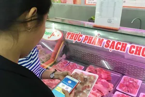Khách hành sử dụng điện thoại thông minh quét mã vạch để biết được nguồn gốc xuất xứ thịt heo