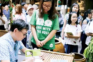 Nhà văn Nguyễn Nhật Ánh ký tặng sách tại Đường sách TPHCM. Ảnh: DŨNG PHƯƠNG