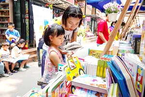 Mẹ và bé lựa chọn sách cho ngày xuân (chụp tại Đường sách TPHCM sáng 12-2). Ảnh: DŨNG PHƯƠNG  