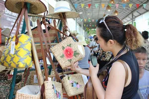 Doanh nghiệp chuyên doanh đa ngành nghề như thủ công mỹ nghệ, mây tre đan… cần thận trọng  khi giao dịch với đối tác ở nước ngoài. Trong ảnh: Khách chọn mua túi xách làm từ lục bình