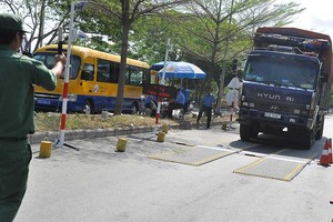 職責人員指引一輛有超載跡象的車輛進入秤車站。