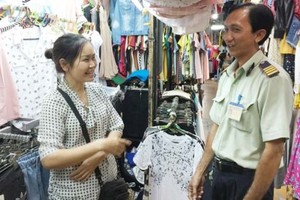 吳氏錦繡商販告知：阮文渥隊長（右）和藹可親，對工作有高度的責任心， 和興街市的商販們都很放心在此經營。