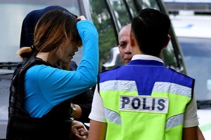 圖為段氏香（左一）在警察保護下押送至法院。（圖源：AFP）