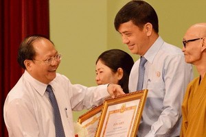 市委常務副書記畢成剛向“學習與傚法胡志明道德榜樣”運動典範授予獎狀。(圖源：互聯網)