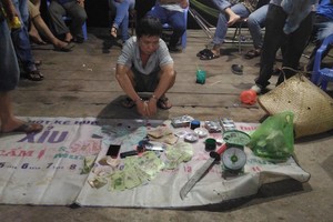 賭博現場人贓並獲40賭徒，逾3億7000萬元、41部手機、27輛摩托車、19隻鬥雞、39副撲克、兩部骰子及1把自製馬刀等贓物。（圖源：芹苴市公安廳提供）