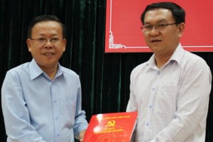 市委組織處主任阮友協向林廷勝(右)同志頒發調動參加平盛郡郡委執委會、常委會及指定出任2015-2020年任期郡委副書記職務的《決定》。（圖源：Q.L）