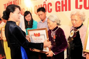 國會主席阮氏金銀向烈屬頒授“祖國記功”證書。(圖源：鄧勇)