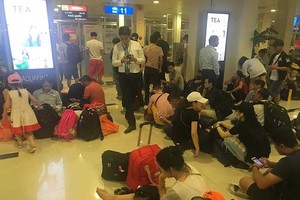 乘客們因為航班多次延後而滯留於機場苦等。