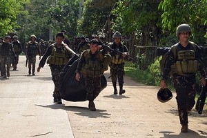 菲律賓政府軍與阿布沙耶夫武裝在菲南部蘇祿省交火，士兵搬運武裝分子遺體。（圖源：互聯網）