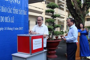 市委書記阮善仁和副書記畢成剛捐款給災民。