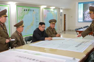 金正恩（右三）聽取有關戰略軍瞄準關島近海射彈方案的報告。（圖源：互聯網）