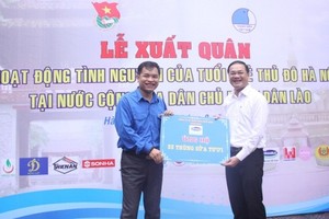 河內市越南青年聯合會主席阮玉越(右)接過老撾各單位代表贈送的禮物。（圖源：互聯網）