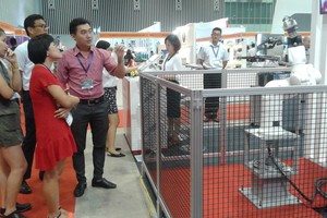 參展商正向客戶介紹由日本生產用以製藥的機器人。