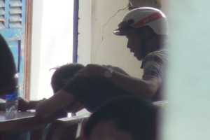 歹徒開門釋放男童後，坐在附近桌子掩面哭泣。（圖源：互聯網）