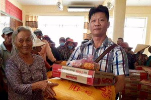 鄭家福向貧困戶派發濟貧禮物。