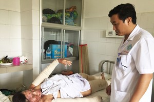 秦玉山醫生在問診灼傷者翁氏簪。（圖源：H.Hoa）