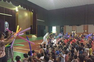 雜技演員送氣球給學生。