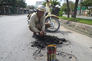 梅文福先生正在修補路面。
