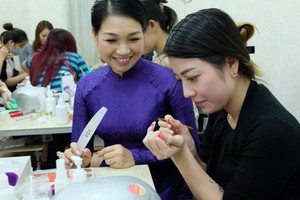 華人美甲師龐美玲（左）正在教學員美甲技藝。