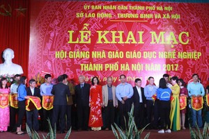 河內勞動與榮軍社會廳領導向參加講學比賽單位贈送紀念旗。（圖源：PV）