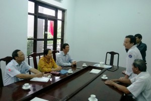 承天-順化省新聞與傳播廳代表人(右二)向黃功傳(左)醫生道歉。（圖源：ĐT）