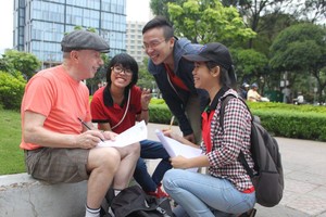 大學生在“九‧二三”公園以英語與外國人溝通。